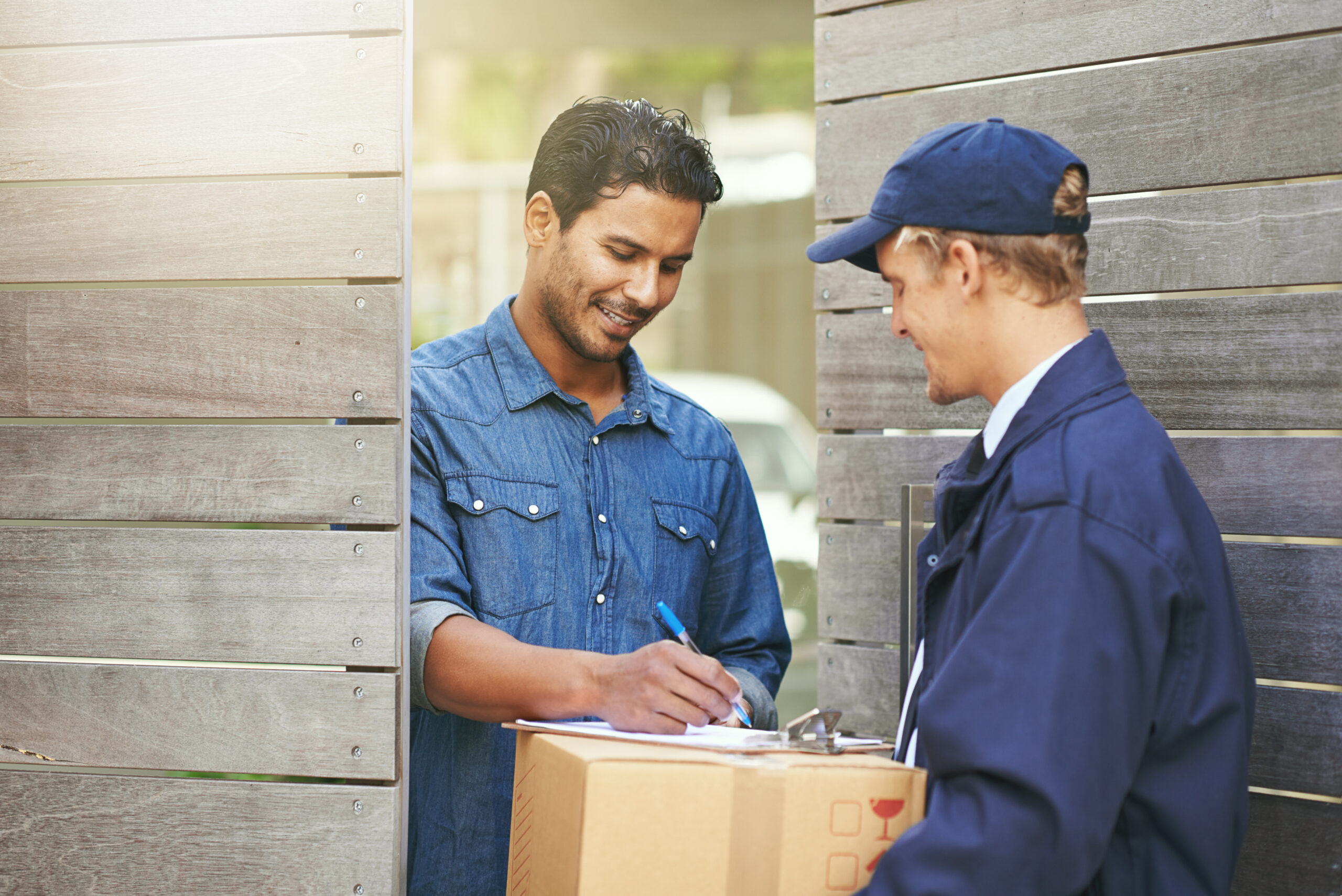 Logistics, customer sign off package from delivery man and crm outdoors at the gate. Ecommerce or courier service, online shopping or product and shipment or exchange between people with signature.