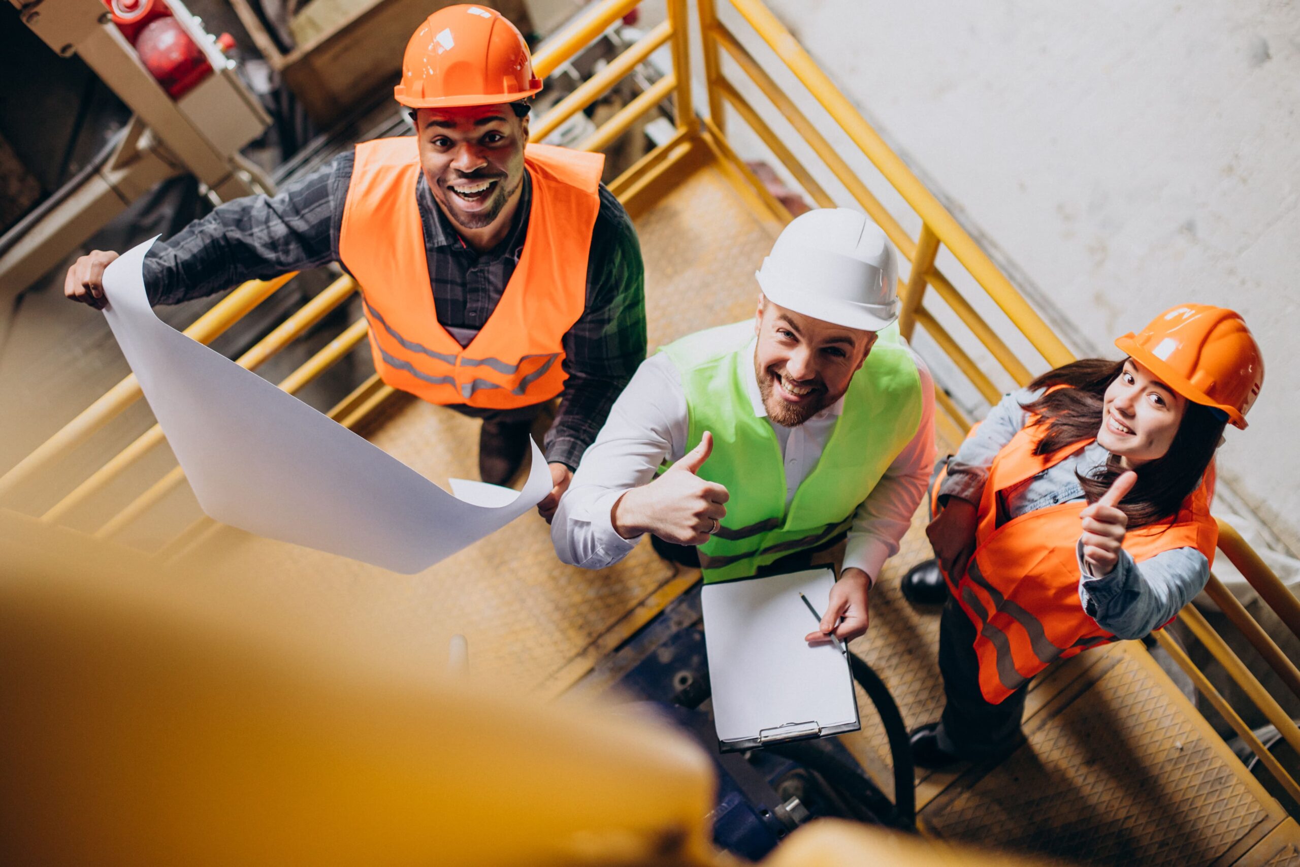 three-factory-workers-safety-hats-discussing-manufacture-plan (1)